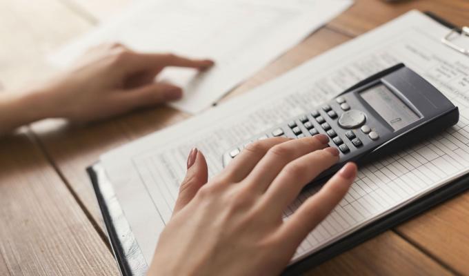 42399-closeup-of-woman-hands-counting-on-calculator-p5fsxnj-min